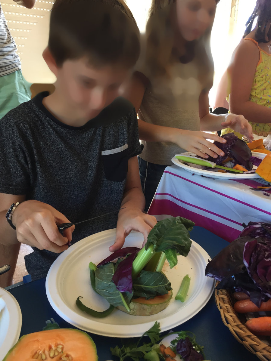 un enfant qui crée une cabane en fruits et légumes